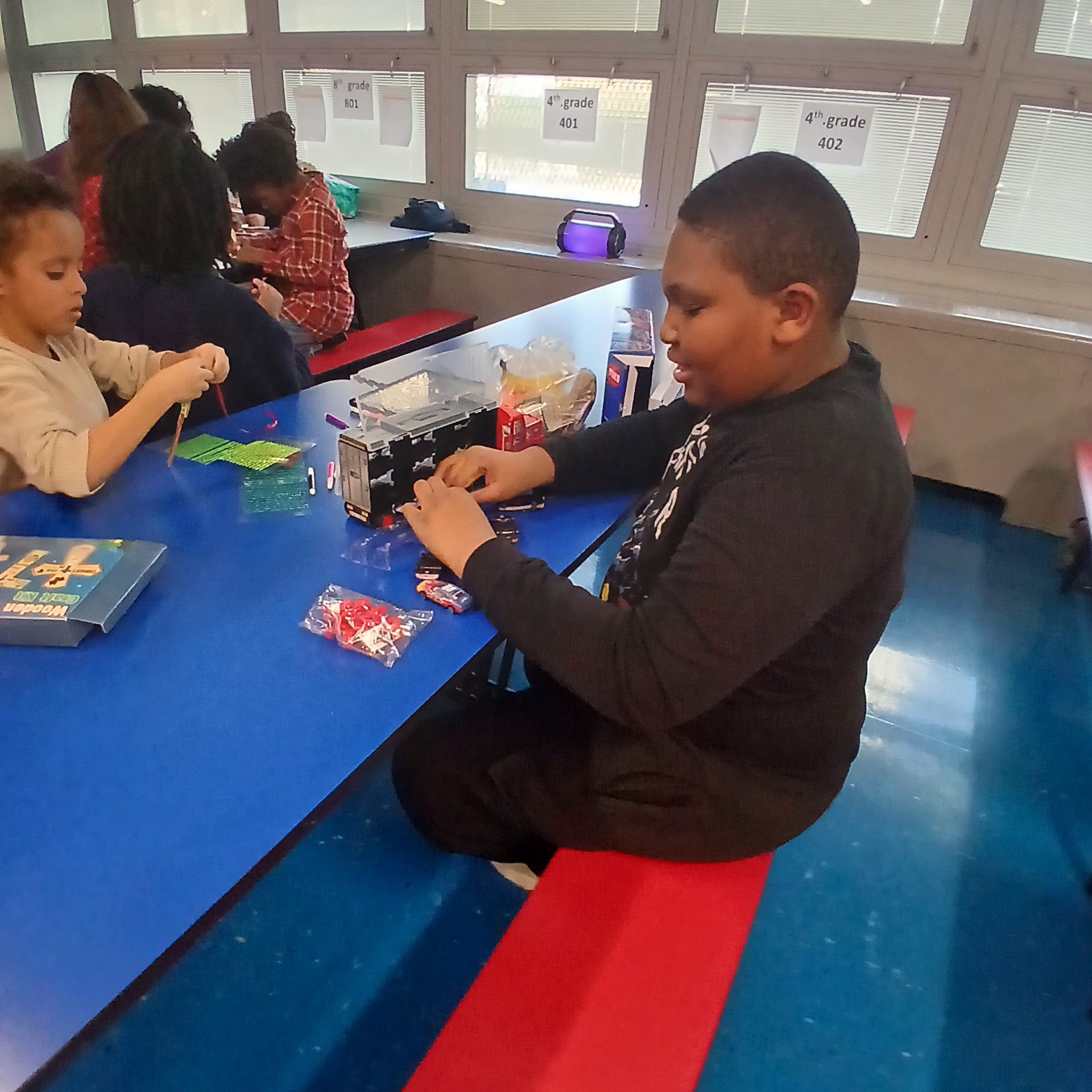 Children sitting together doing activities at tables during the event