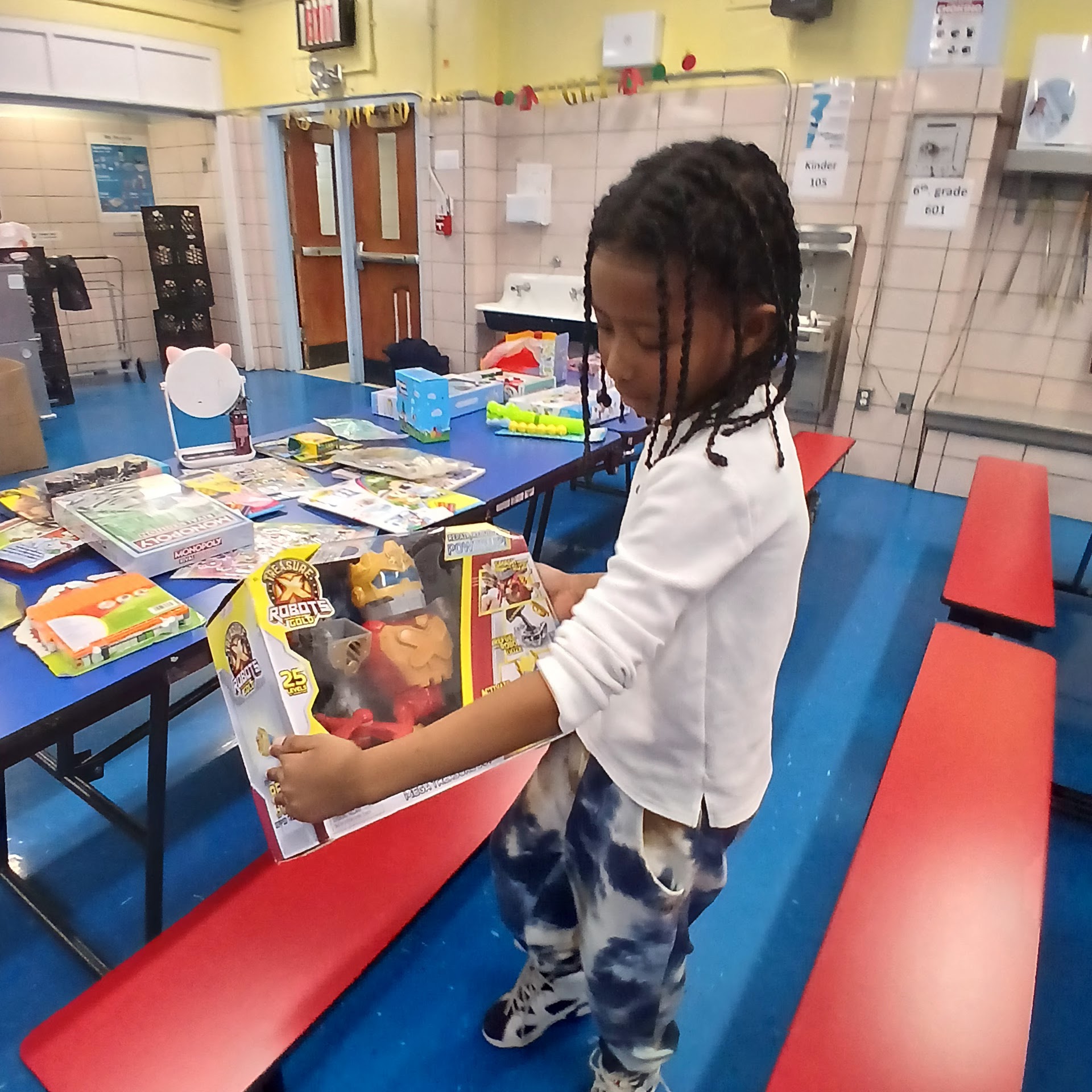 Child carrying a boxed toy through the gift event space
